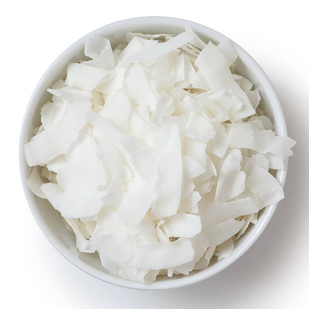 Coconut flakes in white ceramic bowl. From above